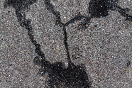 Crack dry asphalt with machine oil texture, good for backgroundの写真素材