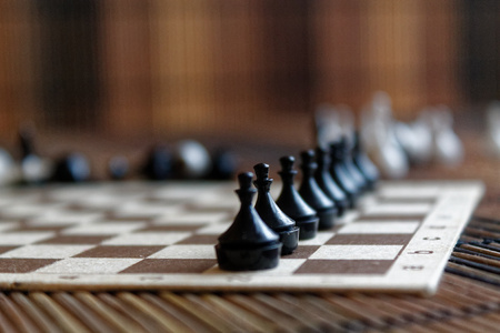Wooden Chess Board and steel chess pieces, isolated on boardの写真素材