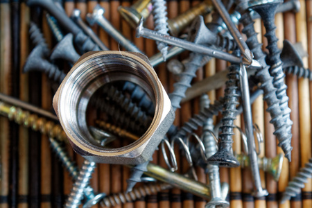 Scattered Screws and bolt isolated on wooden background Texture for web site ot mobile devices,...