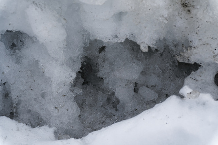 Snow Winter background, close-up of frosted ice lump on a snowing day with copy space.