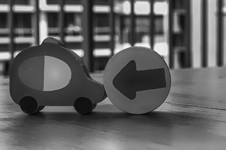 Monochrome Wooden toy cars with arrow on the circle on the table.の写真素材