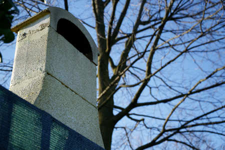 Stone square chimney on the roof in sunny weatherの写真素材