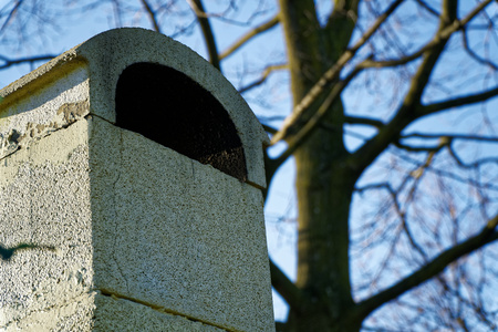 Stone square chimney on the roof in sunny weather