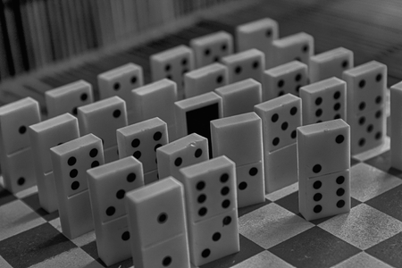 Monochrome Domino pieces in a row, back side on the bamboo brown wooden table background