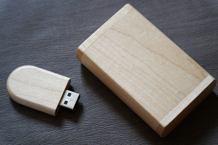 Usb flash drive with wooden surface in wooden box on desk for USB port plug-in computer laptop for transfer data and backup business concept.の写真素材