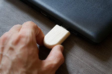 Hand inserting USB flash drive connect to USB port plug-in computer laptop for transfer data and backup business concept.の写真素材