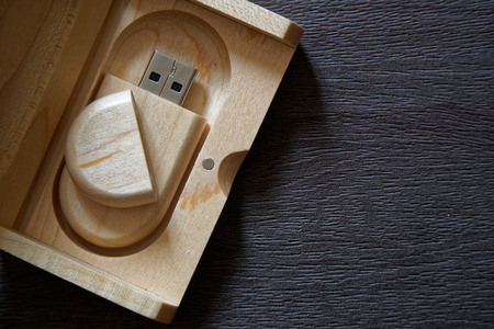 Usb flash drive with wooden surface in wooden box on desk for USB port plug-in computer laptop for transfer data and backup business concept.の写真素材