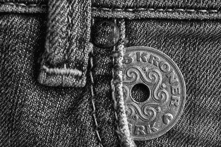 Denmark coin denomination is five krone (crown) in the pocket of old worn denim jeans, monochrome shot.の写真素材