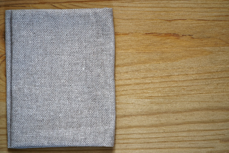 Postcard sample, linen fabric surface on wooden table with free copyspace for greeting text, for mock-up or designer use, book cover sample.の写真素材