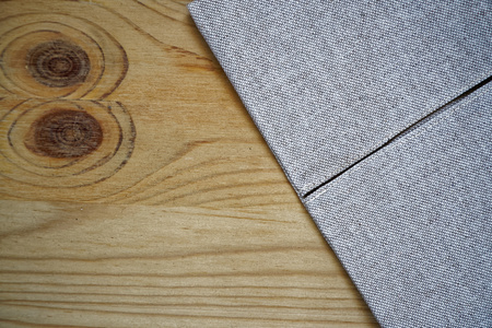 Linen fabric surface on wooden table for mock-up or designer use, book cover sample.の写真素材