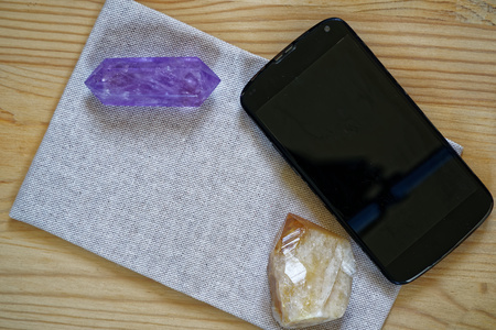 Cellphone with crystals on fabric linen surface, luxury business background.