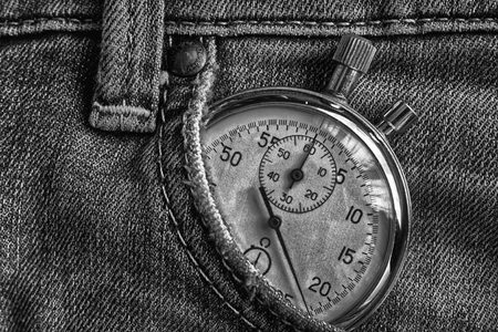 Vintage antiques Stopwatch, in old worn dark denim pocket, value measure time, old clock arrow minute, second accuracy timer record.の写真素材