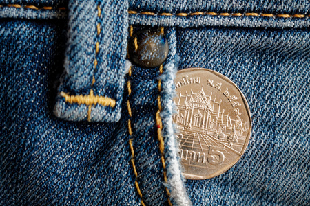 Euro coin with a denomination of twenty euro cents in the pocket of old worn denim jeans