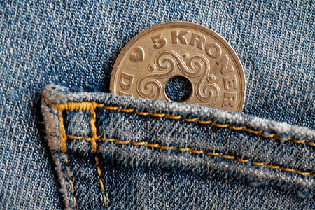 Denmark coin denomination is 5 krone (crown) in the pocket of blue worn denim jeans