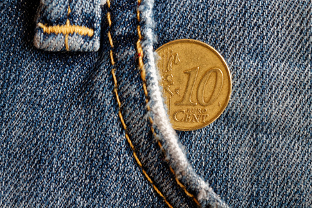 Euro coin with a denomination of 10 euro cents in the pocket of obsolete blue denim jeans
