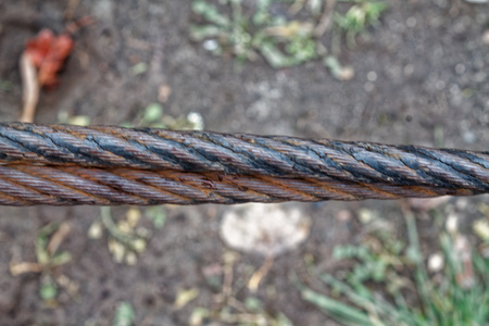Thick steel rope close up. Bridge fence element. Detailed view. The surface of the steel cable is...