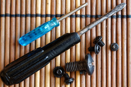 Screws and screwdriver on wooden backgroundの写真素材