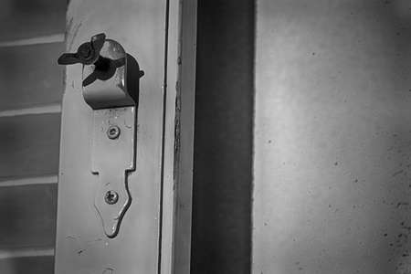 Old window latch with already worn white paint. Focused closely and with space for texts.の写真素材