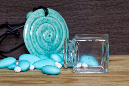 Decorative jar with bow and blue stones inside on wooden table, mockup for postcard or greeting card.の写真素材