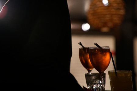 Silhouette of woman drinking alcoholic beverage aperol. Wonderful atmosphere. Enjoying life