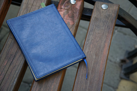 Notebook on bench in park, business concept.
