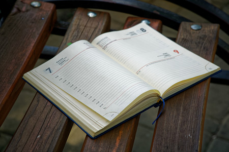 Open Notebook lies bench in park, business concept.の写真素材