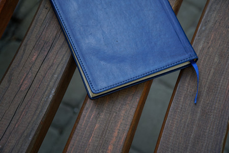 Notebook on bench in park, business concept.の写真素材