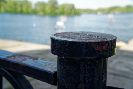 Steel fence in public park, defocused background, near the river.