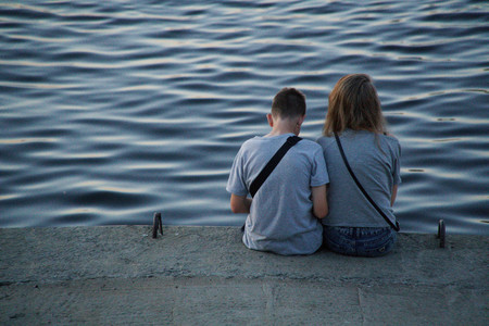 Couple hugs near on river coast, romantic sunsetの写真素材