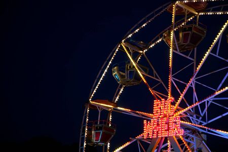 Kyiv - Ukraine, Poshtova square, 13.08.2018: Ferris wheel attraction illuminated with colorful lights in motion.のeditorial素材