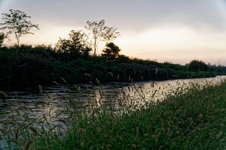 View of river, sunset over mountains, water surface with reflectionの写真素材