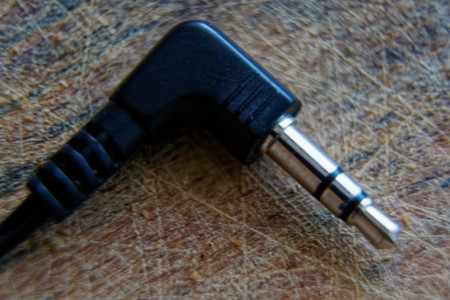 Jack Plug, minijack with cord on wooden table.
