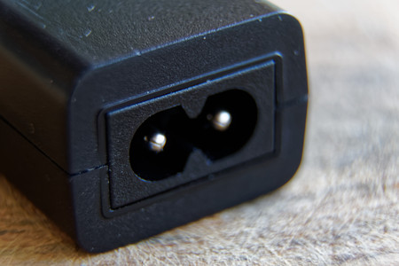Usb charger plug on wooden background, close-up