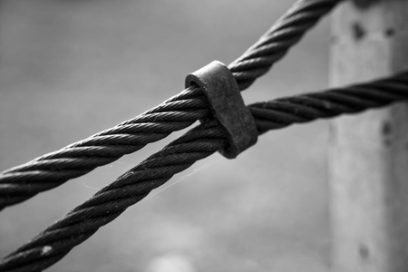 Thick steel rope close up. Bridge fence element. Detailed view. The surface of the steel cable is covered with rust..の写真素材