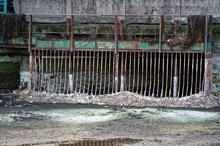 Iron grate of water drain sytem in water canal.の写真素材