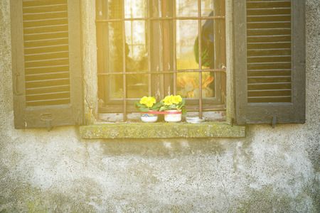 Window in old vintage style with open wooden shutters and fresh flowers.の写真素材