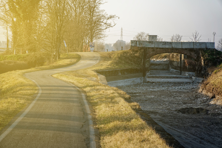 Empty running road near dry water canalの写真素材