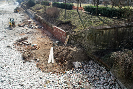 Construction Site damaged wall repairing, construction machinery, bulldozer, excavation factoryの写真素材