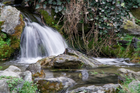 Flowing water stream, water drops and reflection.の写真素材