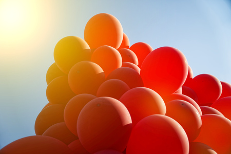Red helium air balloon with calm blue cloudy sky on background. Peace and holiday concept. Bottom view. Copyspace for minimalistic designの写真素材