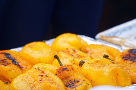 Grilled orange pepper sweet peppers on background, street foodの写真素材