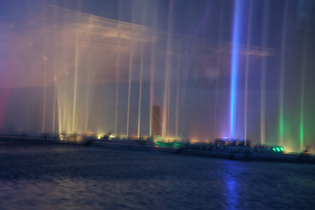 Colorful water fountains with laser and light reflection over lake.の写真素材