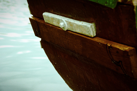 Old wooden boat stern on river and fountain behind.の写真素材