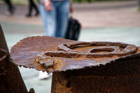 Weathered rusty metal element on the street, shaped detail closeup. Grunge rusty metal texture. Rough dirty surface of metal decorationの写真素材