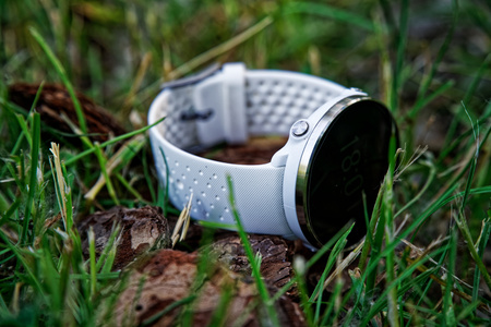 Sport watch for running white color on the ground in the grass. Fitness watch for tracking daily activity and strength trainingの写真素材