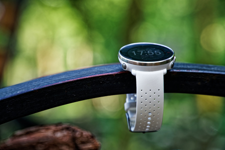 Sport watch for running white color on wooden bench. Fitness watch for tracking daily activity and power trainingの写真素材