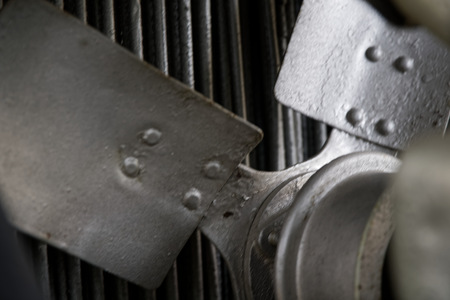 Vintage antique automotive tractor rusty fan blade and belt behind the radiator with pulleys showingの写真素材