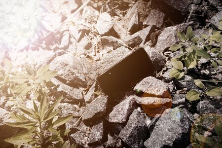 Broken cellphone abandoned and lost among the gravel.の写真素材