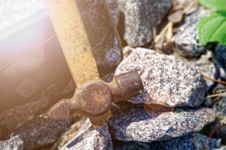 Smartphone broken glass with hammer on gravel stones. Selective focus with sum beam.の写真素材