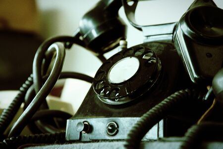 Black retro phone on blurry background. Still life of retro office, telephone on wooden table.の写真素材